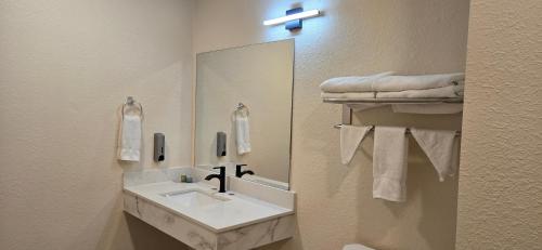 a bathroom with a sink and a mirror and towels at Grapevine Inn in Lodi