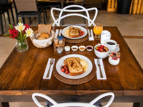 a wooden table with plates of food on it at Casa Swell Coronado, Adults-Only Boutique Hotel, Pool & Beach in Playa Coronado