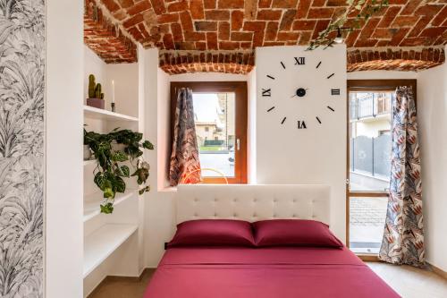 a bedroom with a bed and a clock on the wall at Il Rustico Romantic Suite e Sauna in Ciriè