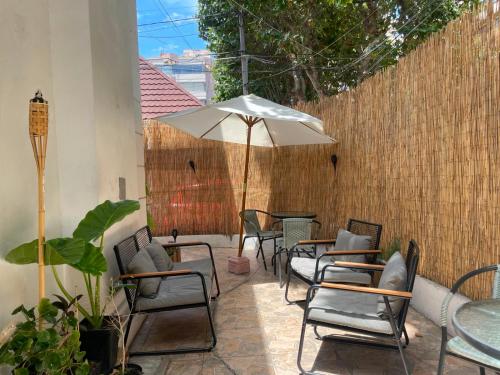 a patio with tables and chairs and an umbrella at Casa Tribu in Viña del Mar