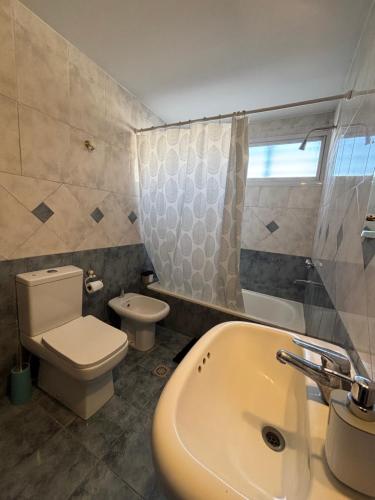a bathroom with a toilet and a sink and a tub at KAD Alojamiento in Mendoza