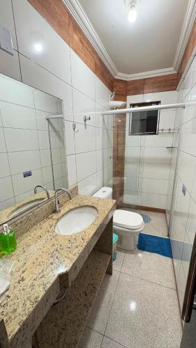 a bathroom with a sink and a toilet at Apart Serra Azul in Santa Bárbara