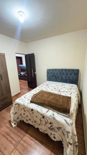 a bedroom with a bed with a blanket on it at Apart Serra Azul in Santa Bárbara