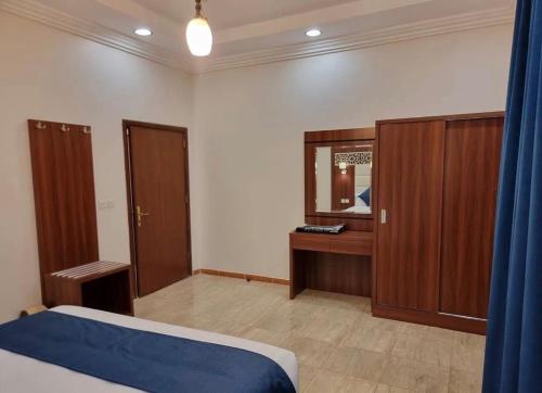 a bedroom with a bed and a dresser and a mirror at ALdyar - Al Qunfudhah in Al Qunfudhah