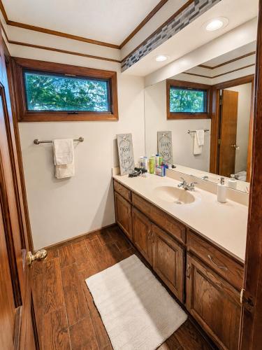 a bathroom with a sink and a mirror at Kaw Drive Guest House in Olathe