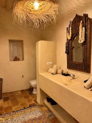 a bathroom with a sink and a mirror and a toilet at Riad chama in Taroudant