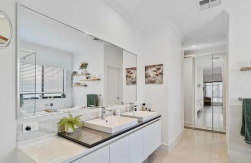 a bathroom with two sinks and a large mirror at Seahawk Escape in Mandurah