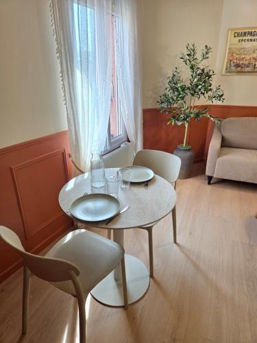 a living room with a table and chairs and a couch at L'Appart Millésime - Escapade champenoise Épernay in Magenta