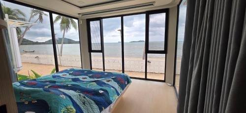 a room with a balcony with a view of the beach at Luxtalay Space Capsule in Ban Thung Makham