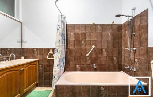 a bathroom with a tub and a sink and a shower at The Thirlmere Homestead in Thirlmere