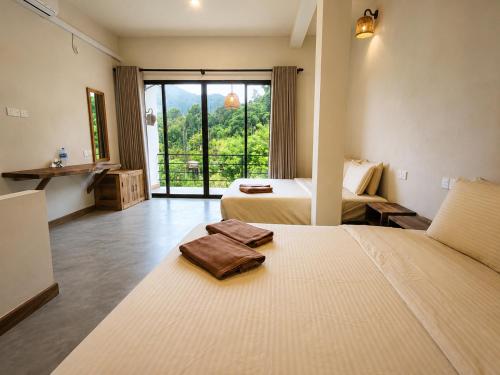 a hotel room with two beds and a large window at Ella Brown House in Ella