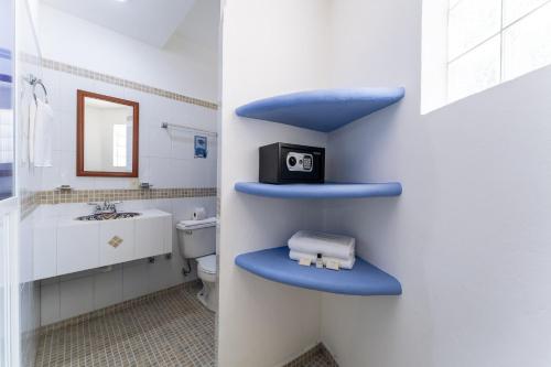 a bathroom with a toilet with a blue shelf at Hotel Mexico Lindo in Santa Cruz Huatulco