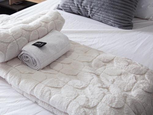 a pile of towels sitting on a bed at The Hideaway Studio-Maboneng in Johannesburg