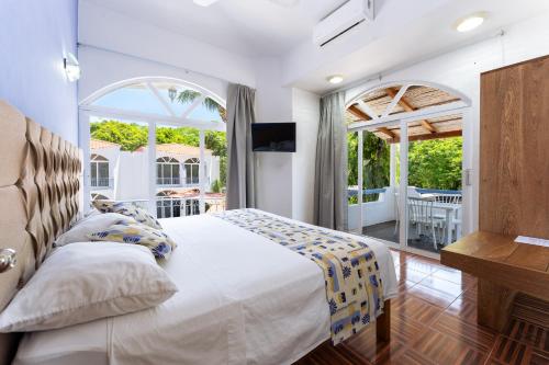 a bedroom with a white bed and a balcony at Hotel Mexico Lindo in Santa Cruz Huatulco