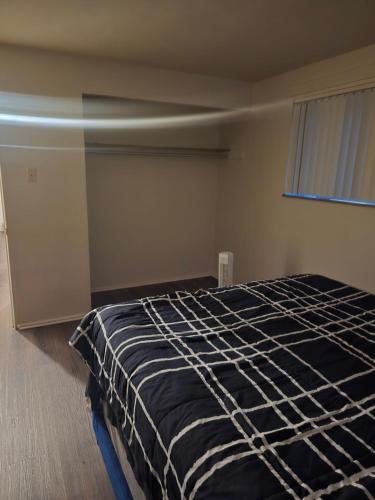 a bedroom with a bed with a black comforter at Cute and Cozy in Hermann I Heliport