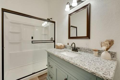a bathroom with a sink and a shower with a mirror at Ozark Mountain Refuge in Kimberling City