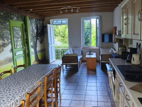 a kitchen and living room with a couch and a table at Ferme bourbonnaise rénovée avec jardin, animaux admis - FR-1-489-295 in Bransat