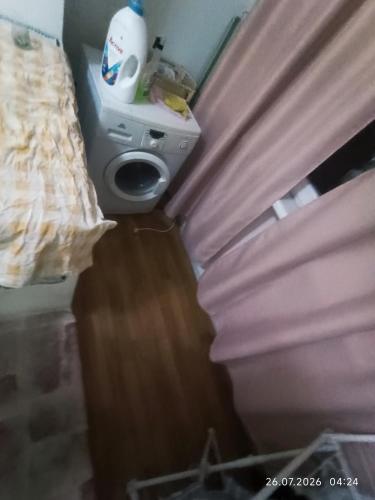 a corner of a room with a bed and a curtain at Gazda ialoveni in Ialoveni