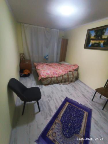 a bedroom with a bed and a chair and a rug at Gazda ialoveni in Ialoveni