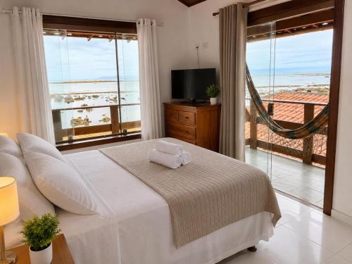 a bedroom with a bed with a view of the ocean at Pousada Villa Grauçá in Morro de São Paulo