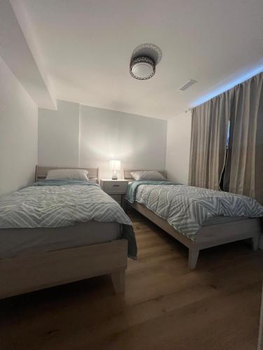 a bedroom with two beds and a window at Cozy Private Basement Suite East Windsor in Windsor