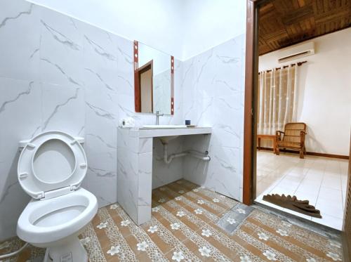a bathroom with a toilet and a sink and a mirror at ASANA Villas in Siem Reap