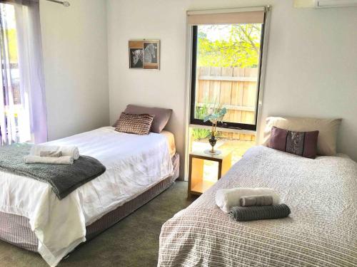 a bedroom with two beds and a window at 2 bedroom private unit with enclosed back yard in Bairnsdale