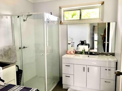 a bathroom with a shower and a sink at 2 bedroom private unit with enclosed back yard in Bairnsdale