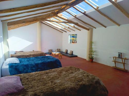 a room with three beds and a ceiling with skylights at Refugio tierra viva in Cusco
