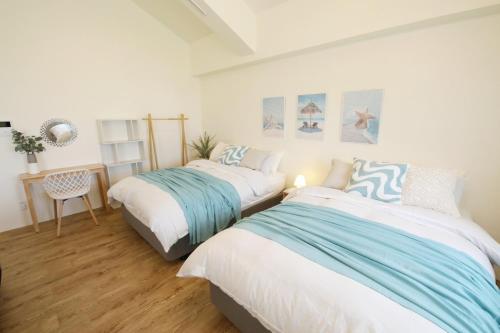 two beds in a room with white and blue at フサキリゾート Ishigaki 201 in Ishigaki Island