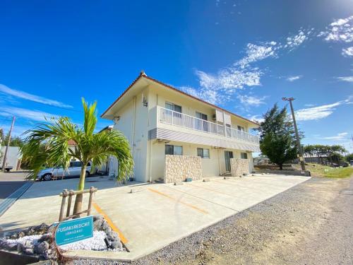 a house with a palm tree in front of it at フサキリゾート Ishigaki 201 in Ishigaki Island