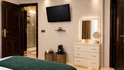 a bedroom with a bed and a television on the wall at Appartement Spacieux 2 Chambres avec vue sur le jardin - Taroudant in Taroudant