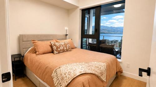 a bedroom with a bed with a large window at Paradise on the Lake in Kelowna