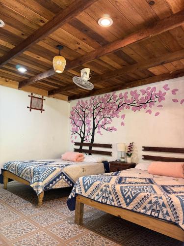 two beds in a room with trees on the wall at Villa Olaya Completo in Xilitla