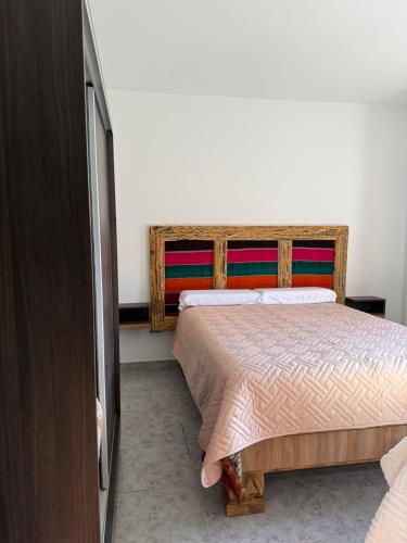 a bedroom with a bed and a dresser at Apart Mirador del Valle in Cachí