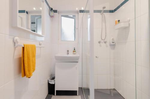 a white bathroom with a sink and a shower at Cute and cozy cottage in Northfield