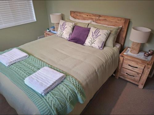 a bedroom with a large bed with pillows at Sunset Te Kamo in Whangarei