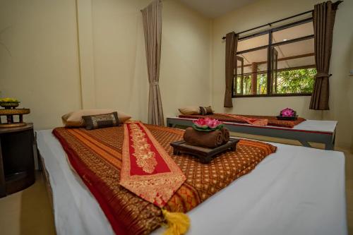 a bedroom with two beds and a window at Wellness World Chiva Khao Yai in Ban Wang Sai