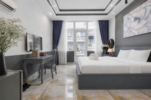 a hotel room with a bed and a desk at GALANG HOTEL in Ho Chi Minh City