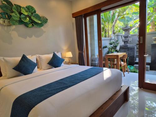 a bedroom with a large bed with a large window at Lavana Ubud in Ubud