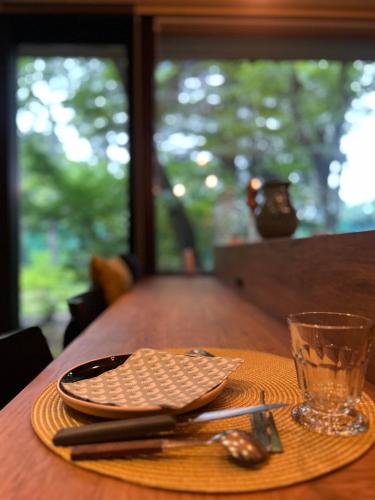 a table with a plate and a glass on it at La Maison Karuizawa in Karuizawa