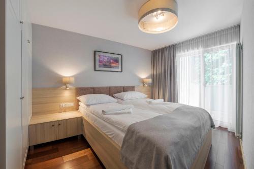 a bedroom with a large bed and a window at Apartamenty MAREA in Jurata