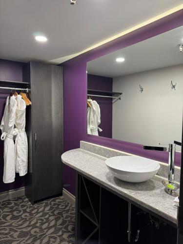a bathroom with a sink and a large mirror at The Royal Anne Hotel in Kelowna