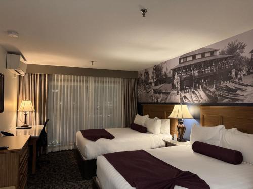 a hotel room with two beds and a painting on the wall at The Royal Anne Hotel in Kelowna