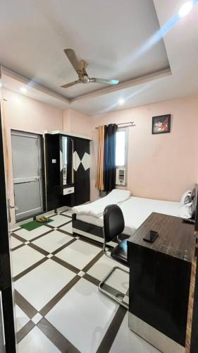 a room with two beds and a chair in it at Hotel shree govind in Orai