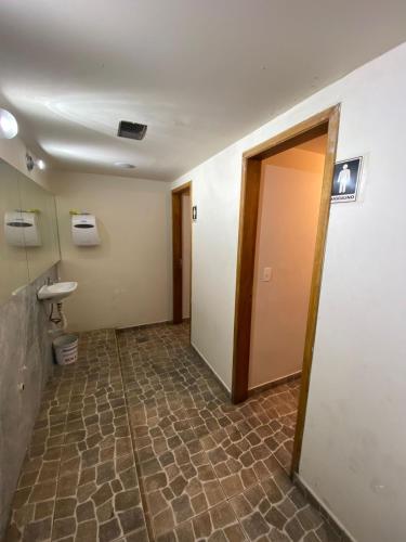 an empty hallway with a toilet and a door at Rede Quartos in São Paulo