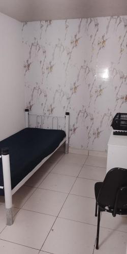 a bedroom with a bed and a desk and a chair at Rede Quartos in São Paulo