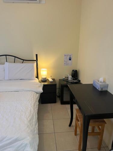 a bedroom with a bed and a desk with a lamp at Maisie Haven in Brisbane