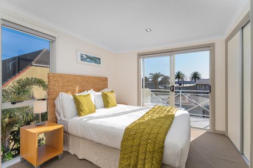 a bedroom with a bed and a large window at Crow's Nest Apartments in Whitianga