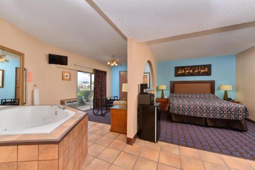 a bedroom with a bed and a bath tub at Economy Inn Ardmore in Ardmore